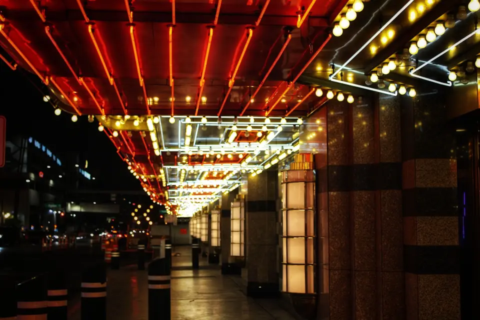 Neon tubes and marquee bulbs lighting a Las Vegas casino walkway at night